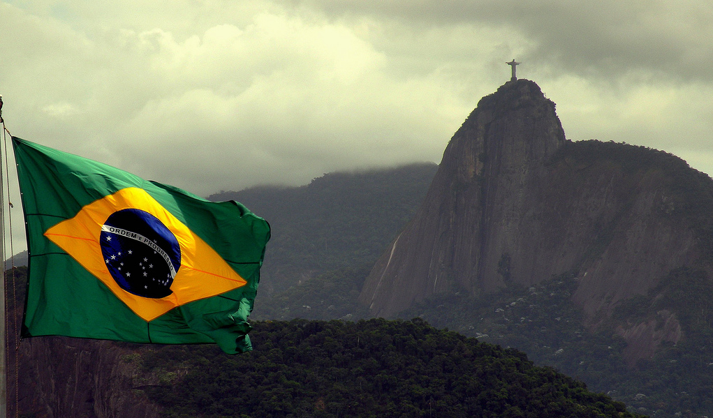 Photo of Brazilian flag waving in front of Corcovado